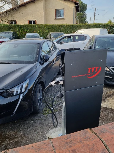 voiture noire en chargement par borne marquée Transports Terrassements Toulousains