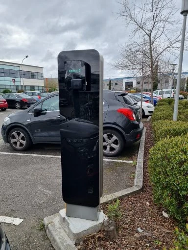 station de recharge noire de marque installée sur un parking d'entreprise